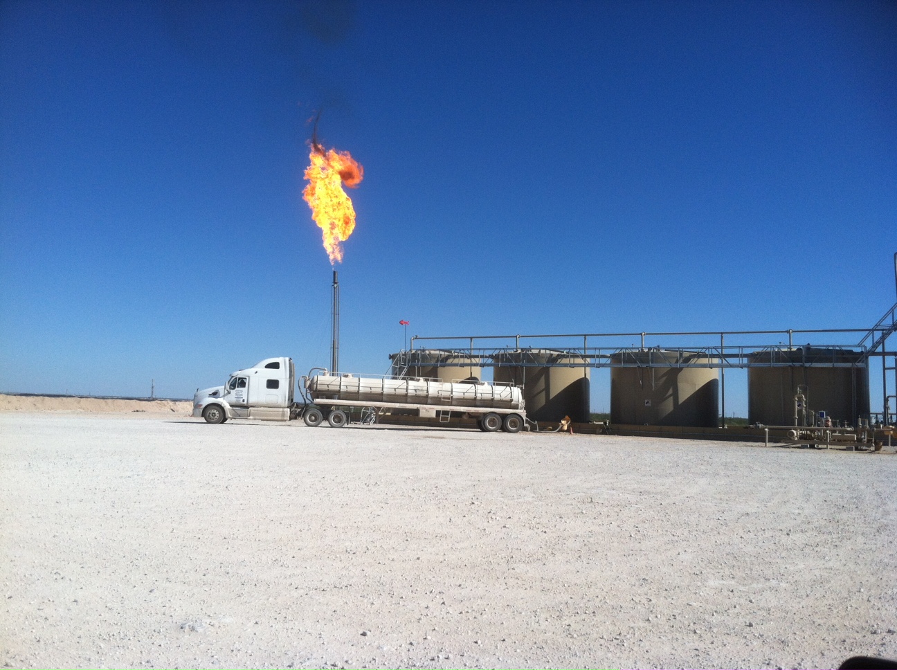 This is the property to the East of ours.  They are pumping oil  and burning off the gas until they get gas lines to the property. image-1
